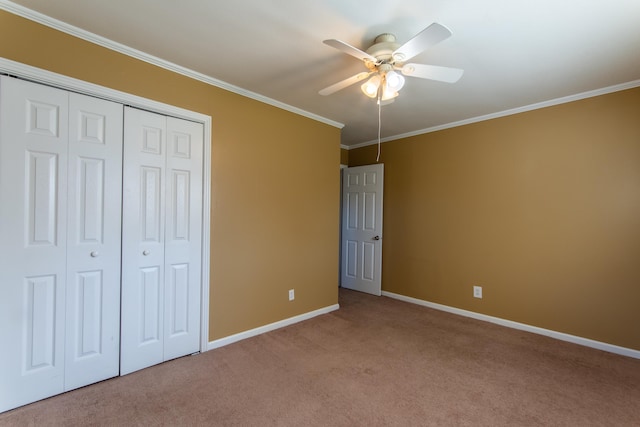 unfurnished bedroom featuring a closet, ceiling fan, carpet flooring, and crown molding