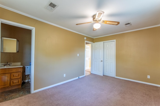 unfurnished bedroom featuring carpet floors, a closet, ceiling fan, ornamental molding, and sink