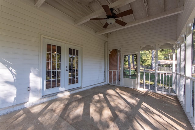 unfurnished sunroom featuring ceiling fan, beamed ceiling, wood ceiling, and french doors