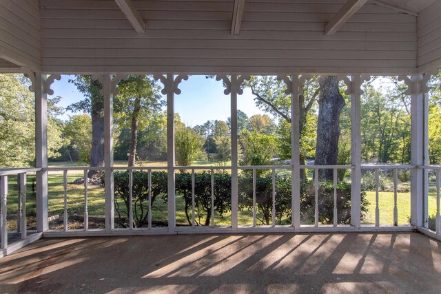 unfurnished sunroom with beam ceiling