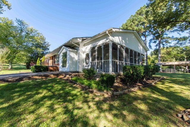 view of front of property with a sunroom and a front lawn