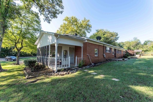 back of house with a lawn and a sunroom