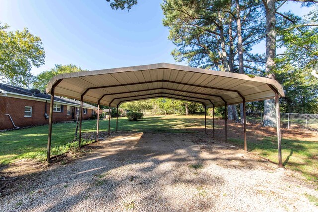 view of vehicle parking with a lawn and a carport