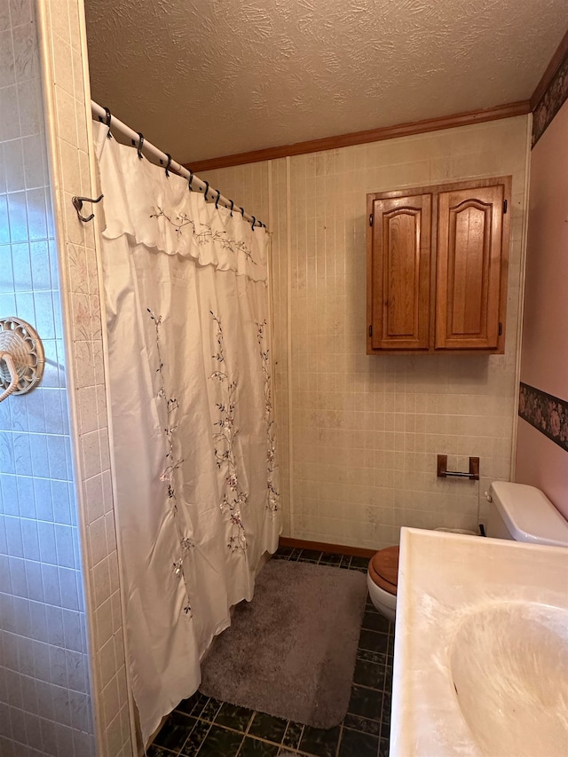 bathroom featuring ornamental molding, a textured ceiling, a shower with curtain, tile walls, and toilet