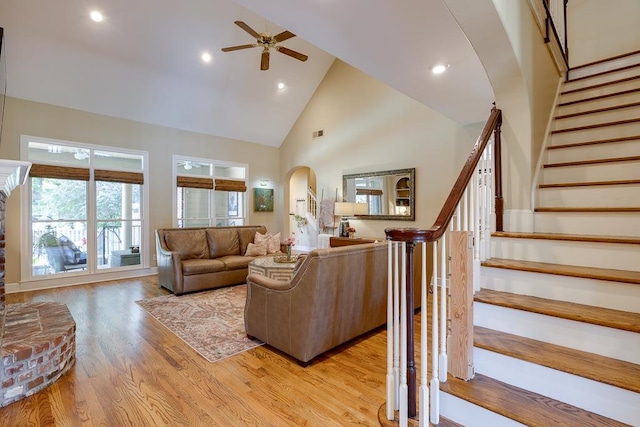 living room featuring ceiling fan, light hardwood / wood-style floors, and high vaulted ceiling