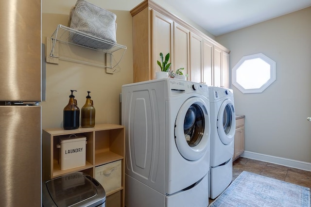 clothes washing area featuring cabinets, separate washer and dryer, and light tile patterned flooring