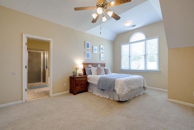 bedroom with ceiling fan, light colored carpet, lofted ceiling, and connected bathroom