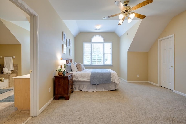 carpeted bedroom featuring ceiling fan, lofted ceiling, and ensuite bath