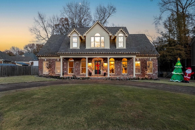 view of front facade with covered porch and a yard