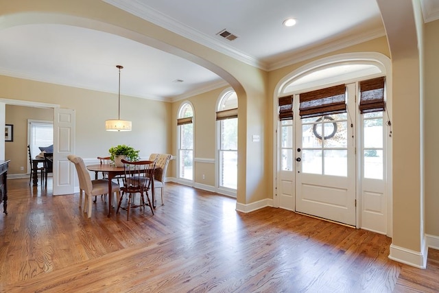 entrance foyer with light hardwood / wood-style flooring, a wealth of natural light, and ornamental molding