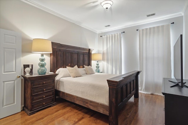 bedroom with hardwood / wood-style flooring and crown molding