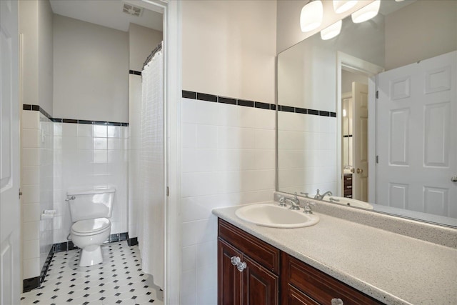 bathroom featuring tile walls, tile patterned flooring, vanity, and toilet