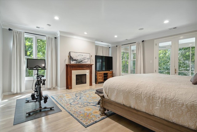 bedroom featuring ornamental molding, light hardwood / wood-style flooring, and access to exterior