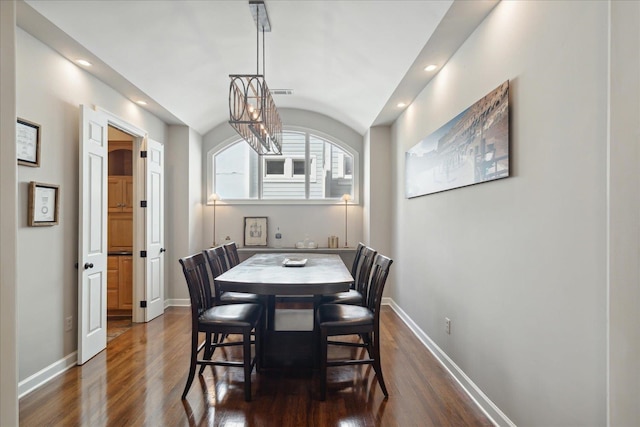 dining room with dark hardwood / wood-style flooring and a chandelier