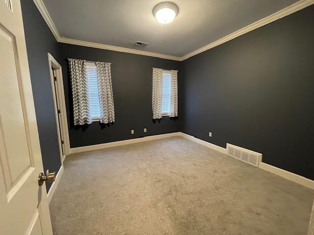 carpeted spare room featuring ornamental molding