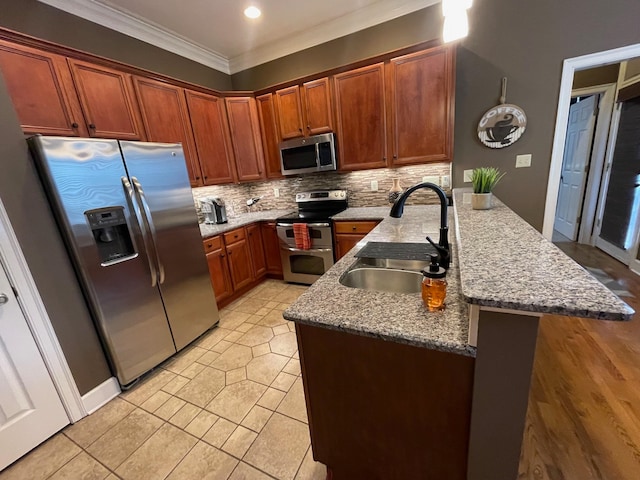 kitchen with tasteful backsplash, kitchen peninsula, stainless steel appliances, ornamental molding, and sink