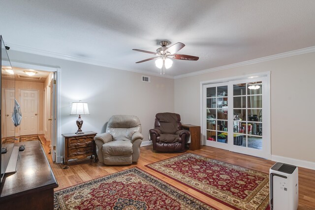 sitting room featuring ornamental molding, ceiling fan, hardwood / wood-style floors, and a textured ceiling