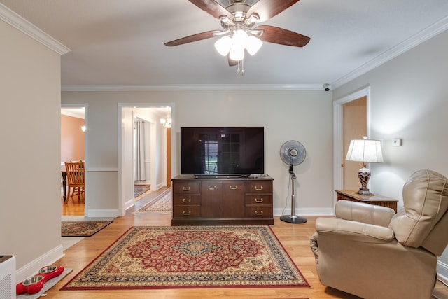 living room with light hardwood / wood-style floors, ceiling fan, and crown molding