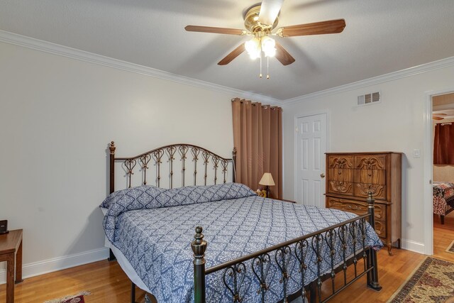 bedroom featuring ceiling fan, hardwood / wood-style floors, and crown molding