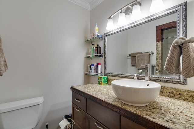 bathroom with vanity, crown molding, and toilet