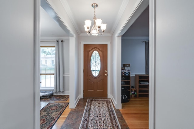 foyer entrance with wood-type flooring, a notable chandelier, and ornamental molding