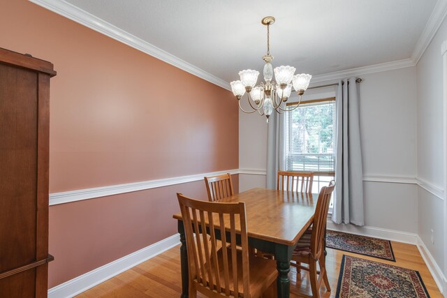 dining room featuring light hardwood / wood-style flooring, a chandelier, and ornamental molding