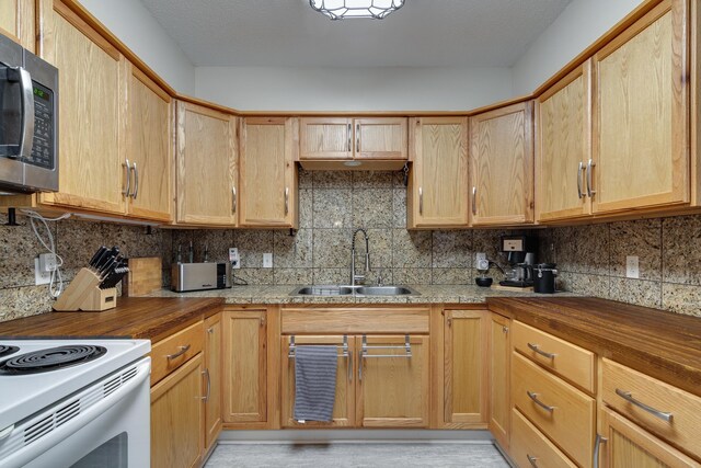 kitchen with sink, tasteful backsplash, a textured ceiling, electric range, and light wood-type flooring