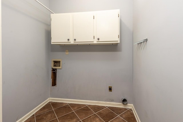 clothes washing area with washer hookup, electric dryer hookup, dark tile patterned flooring, and cabinets