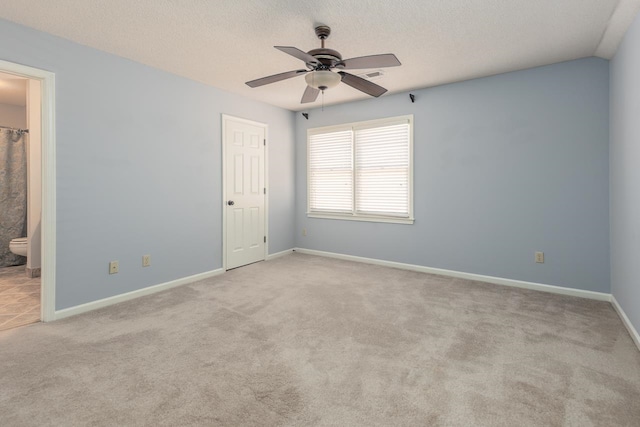 carpeted empty room featuring ceiling fan and a textured ceiling