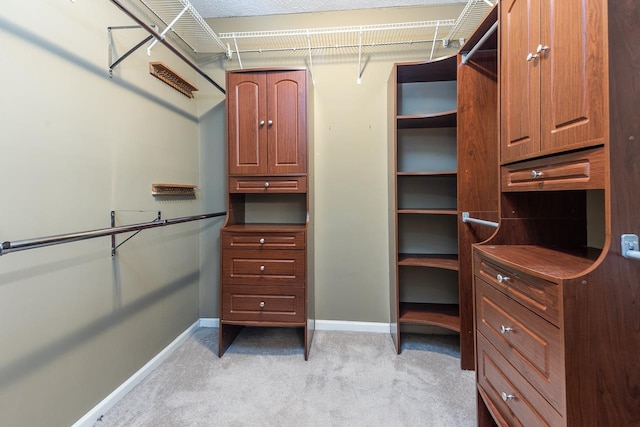 walk in closet featuring light carpet