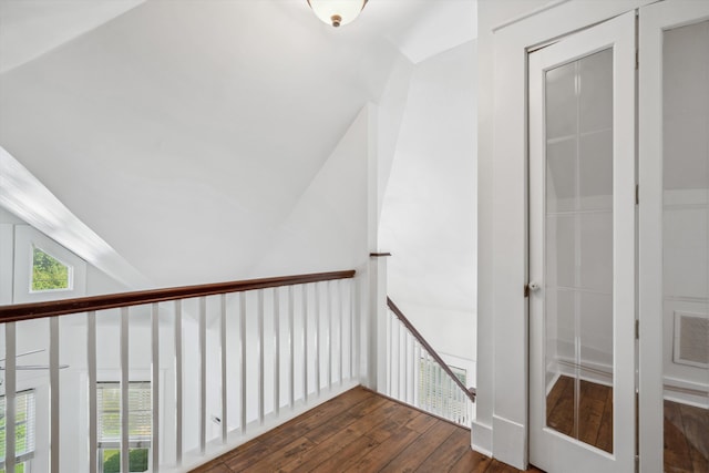 stairway with wood-type flooring and lofted ceiling