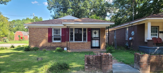 bungalow-style home with a front yard