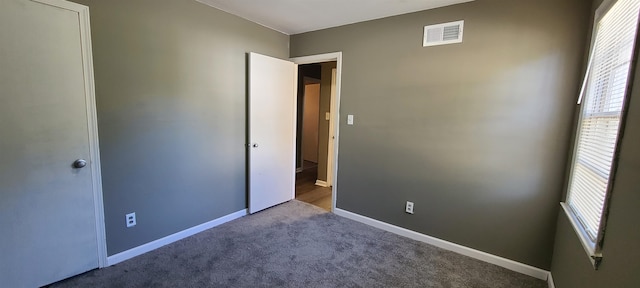 unfurnished bedroom with carpet floors and multiple windows