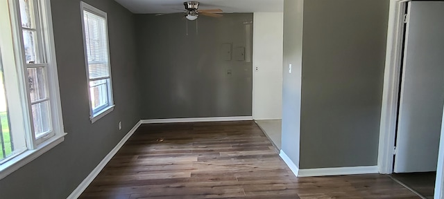 spare room with a healthy amount of sunlight, ceiling fan, and dark wood-type flooring