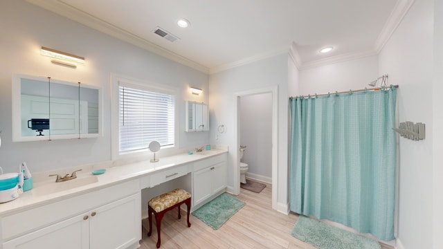 bathroom with ornamental molding, vanity, toilet, and hardwood / wood-style flooring