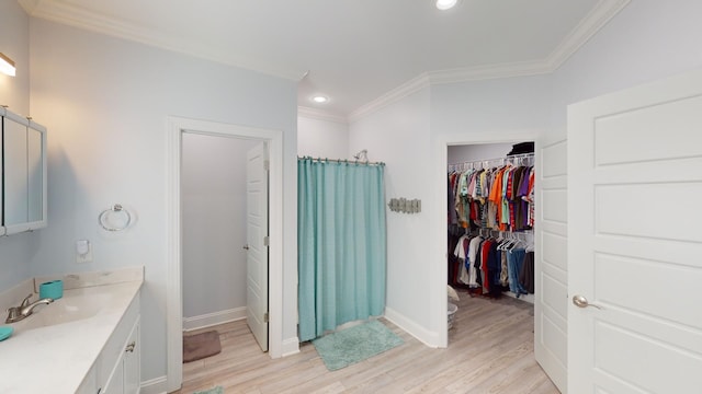 bathroom with vanity, ornamental molding, and hardwood / wood-style flooring