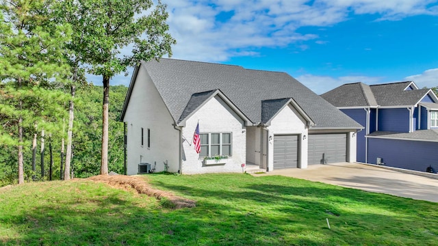 view of front of property with cooling unit, a garage, and a front lawn