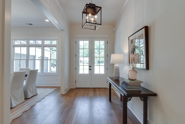 entrance foyer featuring crown molding, a chandelier, french doors, and hardwood / wood-style flooring