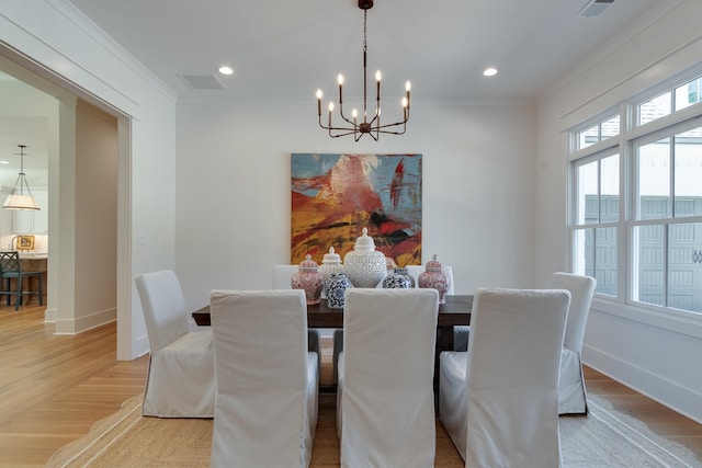 dining space featuring ornamental molding, wood-type flooring, and a chandelier