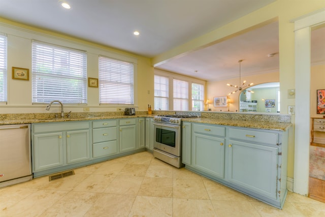 kitchen with light stone counters, stainless steel appliances, an inviting chandelier, decorative light fixtures, and sink