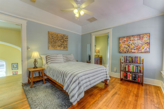 bedroom featuring lofted ceiling, ensuite bath, ceiling fan, and hardwood / wood-style floors