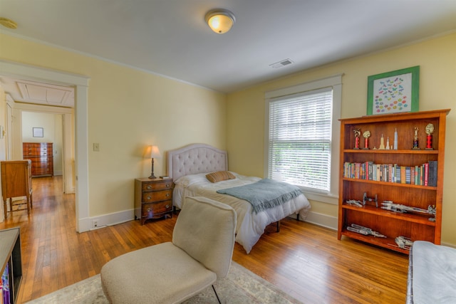 bedroom with wood-type flooring and crown molding