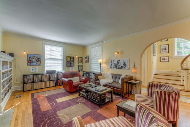 living room featuring ornamental molding, light hardwood / wood-style flooring, and a wealth of natural light