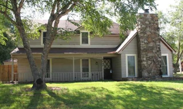 rear view of house with a yard and covered porch