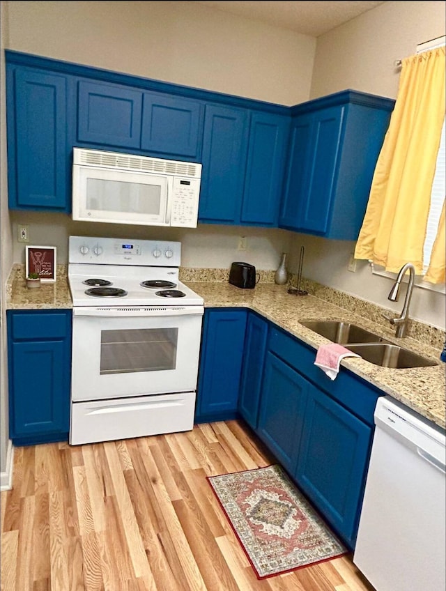 kitchen featuring light stone counters, sink, white appliances, blue cabinetry, and light wood-type flooring