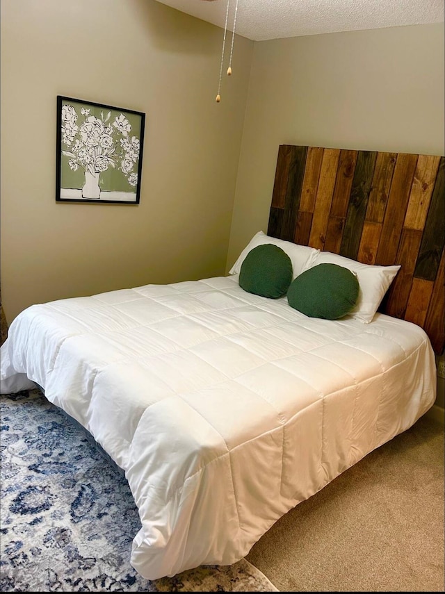 bedroom with a textured ceiling and carpet flooring