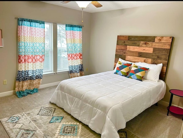 carpeted bedroom featuring ceiling fan and multiple windows