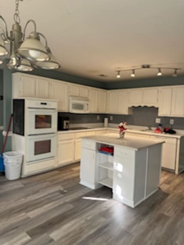 kitchen with white cabinets, a notable chandelier, and white appliances