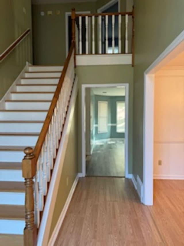 7565 Wintergreen Ln NW, Tn, TN 38018 - staircase with baseboards, a towering ceiling, and wood finished floors