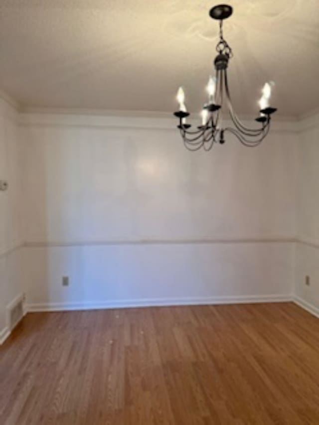 interior space with crown molding, hardwood / wood-style floors, and a chandelier